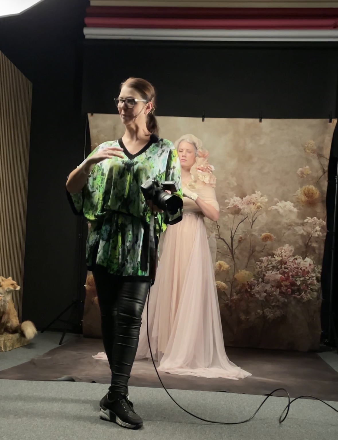 Martina photographing a model in a pink gown during a live workshop